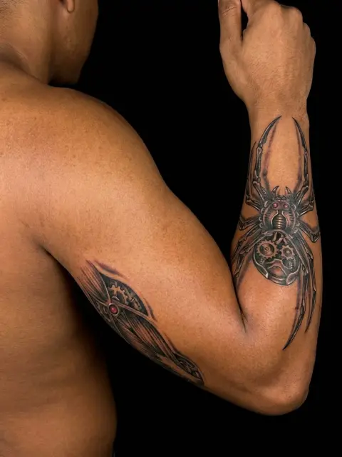 Tatouage biomech avant-bras moyen : robot araignée cyborg marron