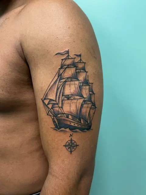 Tatouage marin bateau biceps milieu couleurs sobres