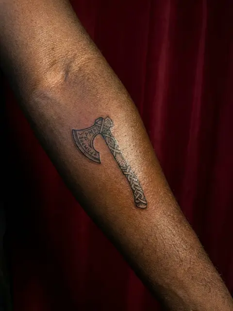 Petit tatouage hache viking avant-bras style nordique
