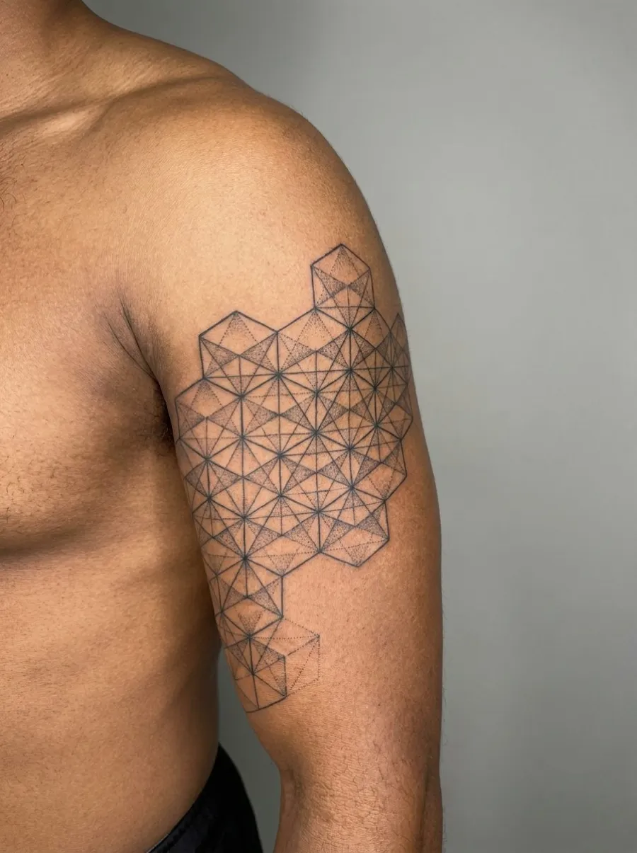 Tatouage géométrique fractal composé d'hexagones et triangles en noir couvrant le biceps, avec lignes précises et ombrage par points